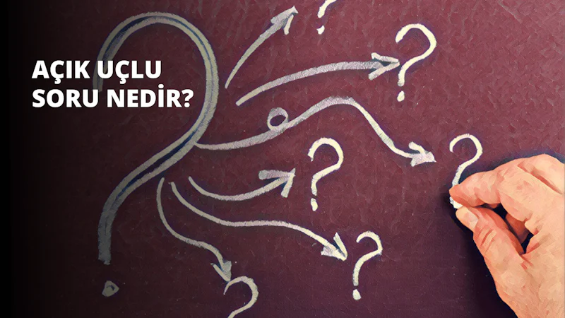 Canlı kırmızı bir yüzey üzerine beyaz tebeşirle çizim yapan bir elin yakından görünümü. Çizim bir dizi ok ve soru işareti içeriyor. Okların ucu sivri ve merkezden spiral bir şekilde uzanıyor. Soru işaretleri hafif kavisli bir şekle sahip olup ortadaki halka dışarıdaki iki halkadan daha büyüktür. Oklar ve soru işaretleri dikkatli ve hassas bir şekilde çizilmiştir, bu da onları yapan kişinin çalışmalarına büyük bir düşünce kattığını göstermektedir. Çizimin arkasındaki arka plan, çeşitli tonlar ve şekiller içeren parlak ve renkli bir tuvaldir.