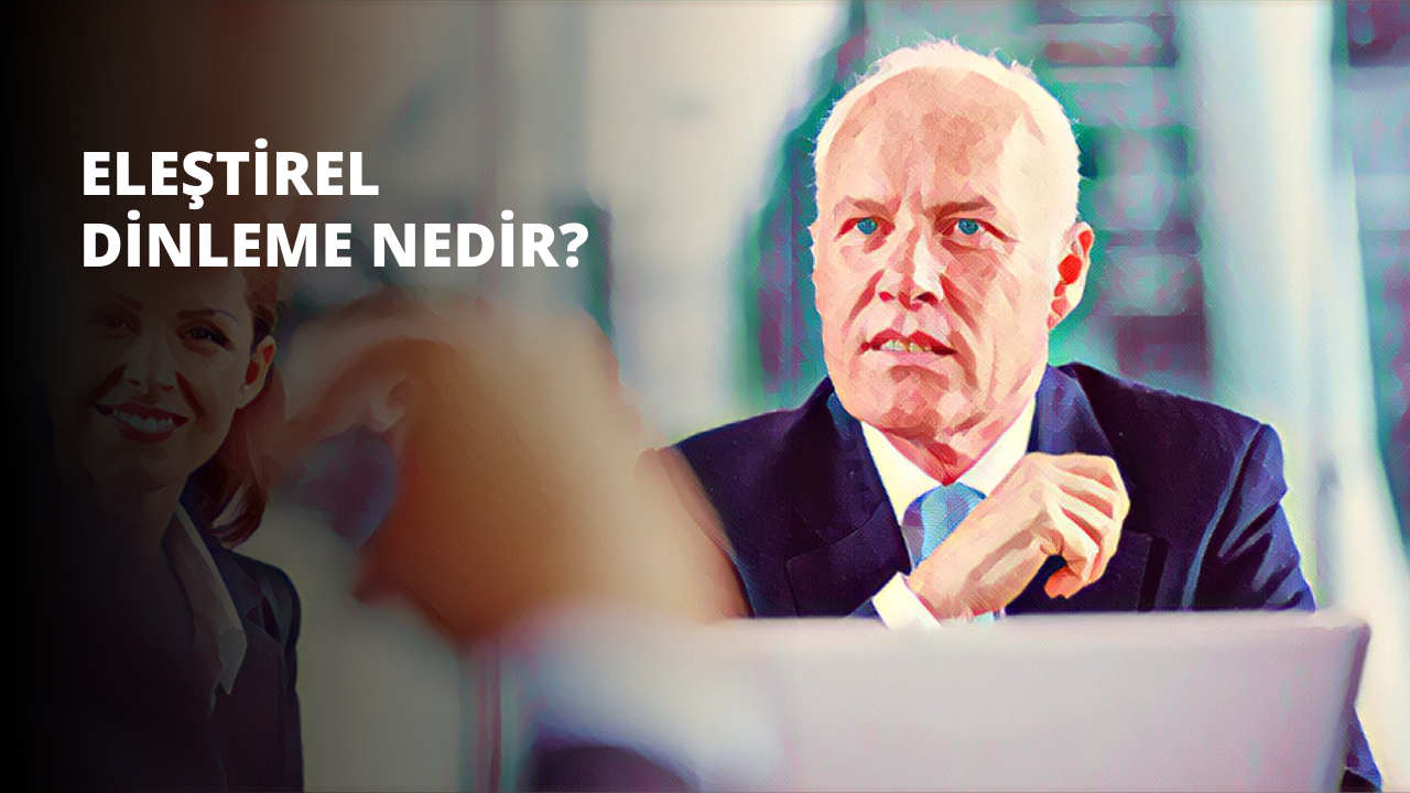 Bu görüntüde koyu renkli bir takım elbise giyen ve kravat takan bir adam görülüyor. Düz bir arka planın önünde duran adamın ışığı düşük ve hafif bulanık. Yüzü görünmüyor ama elleri yakın çekimde görüntünün ön planında yer alıyor. Elleri avuç içleri kameraya bakacak şekilde açık ve parmakları hafifçe birbirinden ayrılmış. Sol kolunda gümüş renkli bir saat takılıdır. Gömleği beyaz renkte ve üzerinde küçük bir desen var.