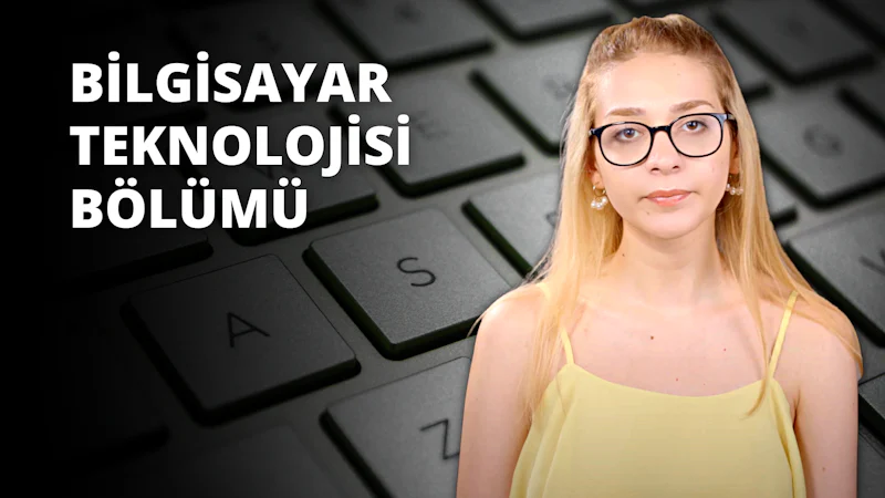 Sarı saçlı ve gözlüklü bir kadın klavyenin önünde durmaktadır. Sarı bir atlet giymiştir ve yüzünde odaklanmış bir ifade vardır. Klavye beyazdır ve tuşların üzerinde siyah harfler ve bazı tuşlarda küçük simgeler vardır. Kadın doğrudan kameraya bakmaktadır, yakın çekimde gözleri görülebilmektedir. Hafifçe öne eğilmiş, elleri klavyenin üzerinde geziniyor. Işık kadının gözlüklerini ve klavyedeki tuşları öne çıkarıyor. Arka plan düz gri bir yüzeydir. Kadın bir şeyler yazıyor ya da yazmaya hazırlanıyor gibi görünüyor.