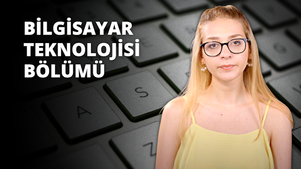 Sarı saçlı ve gözlüklü bir kadın klavyenin önünde durmaktadır. Sarı bir atlet giymiştir ve yüzünde odaklanmış bir ifade vardır. Klavye beyazdır ve tuşların üzerinde siyah harfler ve bazı tuşlarda küçük simgeler vardır. Kadın doğrudan kameraya bakmaktadır, yakın çekimde gözleri görülebilmektedir. Hafifçe öne eğilmiş, elleri klavyenin üzerinde geziniyor. Işık kadının gözlüklerini ve klavyedeki tuşları öne çıkarıyor. Arka plan düz gri bir yüzeydir. Kadın bir şeyler yazıyor ya da yazmaya hazırlanıyor gibi görünüyor.