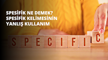 Elini tuğla bir duvara dayamış bir kişi görülüyor. Ön planda, üzerinde ahşap bloklar ve kırmızı harfler bulunan bir masa var. Bloklar düzgün bir şekilde dizilmiş ve kırmızı harfler açıkça görülebiliyor. Yakından bakıldığında, blokların üzerindeki sözcüklerin yanı sıra bir kişinin kolu ve eli de görülebiliyor. El, üzerinde beyaz yazılar görünen bir blok tutmaktadır. Arka planda, üzerinde kelimeler yazılı bir tabela görülüyor. Görüntüdeki tüm unsurlar nettir ve sahnenin net bir şekilde görülmesini sağlar.