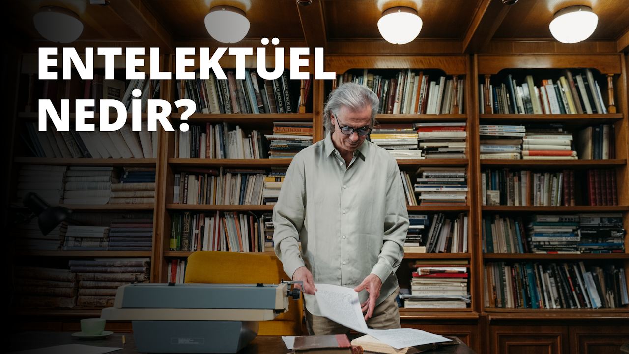 Bir adam, birkaç rafı olan uzun ahşap bir kitaplığın önünde duruyor. Gözlük takıyor ve yüzünde ciddi bir ifade var. Gri bir gömlek ve mavi bir kot pantolon giyiyor. Kitaplığın kenarları boyunca uzanan beyaz bir şerit vardır. En alt rafta, tabağı olan beyaz bir fincan var. Adamın üzerinde yuvarlak ampullü bir aydınlatma armatürü var. Kitaplığın sağ tarafında, bir kitap rafının bulanık bir fotoğrafı var.