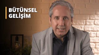 Takım elbiseli bir adam kahverengi bir duvarın önünde dururken gülümsüyor. Beyaz bir elbise gömleği, siyah bir kravat ve siyah bir takım elbise ceketi giyiyor. Saçları gri ve kulağında bir küpe var. Dudakları yakın görünmektedir ve güçlü bir çenesi vardır. Arkasındaki duvarda, kahverengi yüzey üzerinde beyaz bir harf var. Sağ alt köşede, açık ve odak dışı bir ampul var.