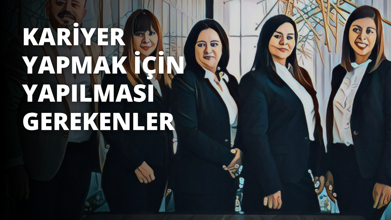 Beş kadından oluşan bir grup yan yana durmuş, fotoğraf çektirmek için poz veriyor. İlk kadın siyah bir ceket, beyaz bir gömlek ve pembe bir etek giyiyor. Gülümsüyor ve doğrudan kameraya bakıyor. İkinci kadın siyah bir ceket, beyaz bir gömlek ve mavi bir etek giyiyor. Kollarını kavuşturmuş ve yüzünde hafif bir gülümsemeyle solda durmaktadır. Üçüncü kadın siyah bir takım elbise ceketi, beyaz bir gömlek ve siyah bir etek giyiyor. Elleri kalçalarında ve yüzünde bir gülümsemeyle ortada duruyor. Dördüncü kadın siyah bir takım elbise ceketi, beyaz bir gömlek ve kahverengi bir etek giyiyor. Elleri kalçalarında ve yüzünde hafif bir gülümseme ile sağ tarafta duruyor. Beşinci kadın siyah bir takım elbise ceketi, beyaz bir gömlek ve gri bir etek giyiyor. Kollarını kavuşturmuş ve yüzünde bir gülümsemeyle sağ tarafta duruyor. Beş kadın da birbirine yakın duruyor ve hepsinin gözleri kameraya odaklanmış durumda.