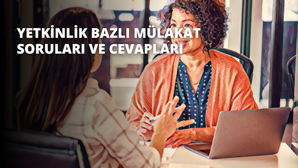 Bir kadın önünde dizüstü bilgisayarıyla bir masada oturuyor. Masadaki diğer kadınla konuşurken yüzünde neşeli bir ifade var. Diğer kadın kıvırcık saçlı ve kırmızı bir eşarp takıyor. Odaktaki dizüstü bilgisayar ekranında arka planı bulanık bir çocuk eli görülüyor. Dizüstü bilgisayarı tutan kadın beyaz bir gömlek giymiş ve kollarını önünde kavuşturmuştur. Dizüstü bilgisayarın etrafında bazı kağıtlar ve bir fincan kahve var. Aydınlık odanın duvarları sarı, köşede mavi bir halı ve yeşil bir bitki var. İki kadın sıcak ve rahat bir atmosferle çevrilidir.