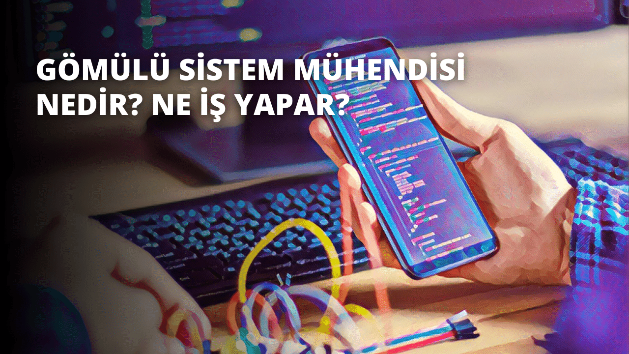 Bir kişi elinde klavyesi ve ona bağlı birden fazla kablosu olan bir cep telefonu tutmaktadır. Telefon sıkıca ellerinde tutuluyor ve odak noktası telefonun kendisi, arka plan ise bulanık. Telefon parlak renklidir ve bilgisayar klavyesine bağlı sarı bir kablo vardır. Kişinin yüzü yakın plandadır ve gözleri, burnu ve ağzı net bir şekilde görülebilmektedir. Klavyede bazıları yanan birden fazla düğme vardır. Kablolar telefondan bilgisayara bağlanarak bir bağlantı sağlamaktadır.