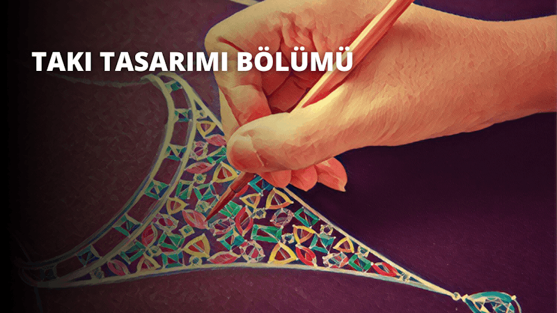 Bir kişinin elinin yakın çekimi gösteriliyor, bir kalemi tutuyor ve bir tasarım çiziyor. Kişinin teni soluktur ve kalemi işaret ve orta parmağı arasında sıkıca tutmaktadır. Çizilen tasarım hassas çizgiler ve açılarla karmaşık ve ayrıntılıdır. Elin altındaki yüzey açık gri renktedir ve arka plan odak dışıdır. El bir ışık kaynağıyla aydınlatılmıştır ve odak kalemin ve çizilen tasarımın üzerindedir. Görüntü canlı ve ayrıntılar keskin, kalem ve tasarım çerçevenin çoğunu kaplıyor.