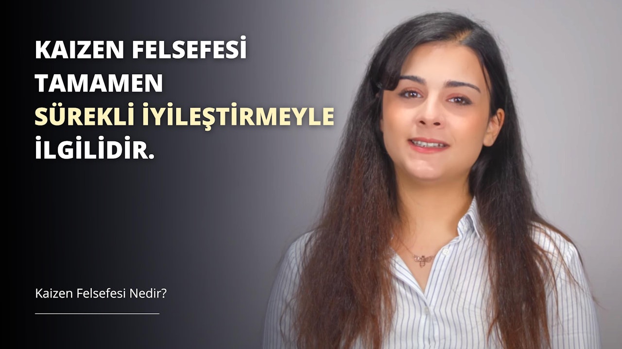 Uzun, kahverengi saçlı bir kadın siyah beyaz arka plana sahip bir odada durmaktadır. Bir kolye takıyor ve ağzını hafifçe açarak parlak beyaz dişlerini ortaya çıkarıyor. Saçları neredeyse omuzlarına kadar uzanıyor ve teni ışıkta parlıyor. Sol kulağında küçük bir küpe var ve görüntünün ön planında birkaç küçük, beyaz harf görülebiliyor. Harfler siyah bir zemin üzerine yazılmış gibi görünüyor ve muhtemelen bir işaretin parçası olabilirler.