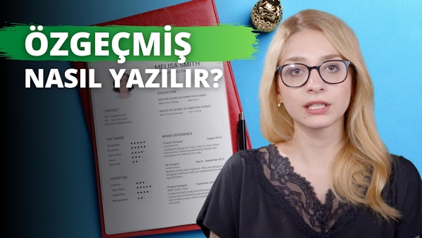 Gözlüklü bir kadın, önünde açılmış bir not defteri ile bir masada oturuyor. Siyah bir gömlek giymiş ve arkasında mavi bir fon var. Deftere konsantre olurken yüzünde ciddi bir ifade vardır. Sağındaki masanın üzerinde altın bir ananas var. Arka planda, üstünde kalem olan kırmızı bir klasör var. Kadın çok odaklanmış görünüyor ve gözleri, ağzı ve göğsü yakından görülüyor. Ayrıca ön planda bir cüzdan görülüyor. Derin düşüncelere dalmış gibi görünüyor, muhtemelen düşüncelerini deftere geçiriyor.