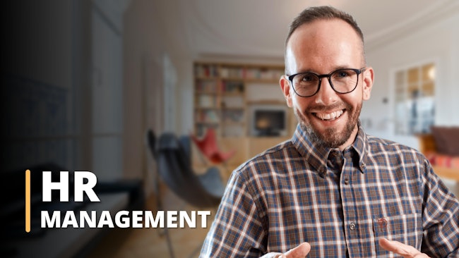 This image shows a knowledgeable academic instructor specialising in Human Resource Management. Dressed in a plaid shirt with blue, brown and orange checkered detailing, the instructor stands in front of a blurred backdrop reminiscent of an HR office. The 8K high-resolution photo proves its authenticity. The HR Management caption on the image clearly demonstrates the relevance of the HR certification and states that the training offered provides students with valuable skills in Human Resource Management. The image undeniably confirms that training in Human Resources is available for those who want to learn more in this field.