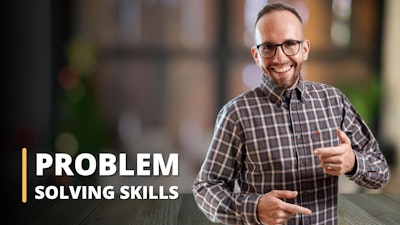 Featured in this image is an instructor, set against the blurred backdrop of a pleasing room with two large windows. Dressed in a brown and white checkered shirt, the instructor is visibly illustrating a problem-solving strategy. This image signifies a training session, tailored for individuals seeking to strengthen their problem-solving skills. It's evident that the online course encompasses vital elements like problem-solving and decision-making, critical thinking, and enhances the learner's overall problem-solving ability. This picture unmistakably showcases an educational setting where these significant skills are imparted to students.