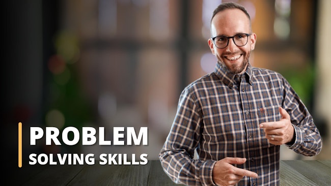 Featured in this image is an instructor, set against the blurred backdrop of a pleasing room with two large windows. Dressed in a brown and white checkered shirt, the instructor is visibly illustrating a problem-solving strategy. This image signifies a training session, tailored for individuals seeking to strengthen their problem-solving skills. It's evident that the online course encompasses vital elements like problem-solving and decision-making, critical thinking, and enhances the learner's overall problem-solving ability. This picture unmistakably showcases an educational setting where these significant skills are imparted to students.