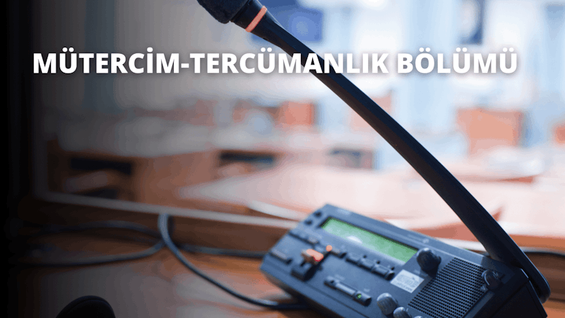 Bu görüntü, ön planda bir mikrofon ve bir cihazın göründüğü bir cihazın yakın çekimini göstermektedir. Mikrofon küçük, siyah bir kafası olan gri, silindirik bir nesne, cihaz ise birkaç düğmesi ve tepesinde küçük bir ekranı olan siyah dikdörtgen bir kutu. Arka planda bir bilgisayar faresi ve sağda bulanık bir bilgisayar görüntüsü görülüyor. Mikrofon hafifçe merkezin dışına yerleştirilmiş ve cihaz hafifçe bulanık ve odak dışı. Görüntü sıcak, sarımsı bir renk tonuna sahiptir.