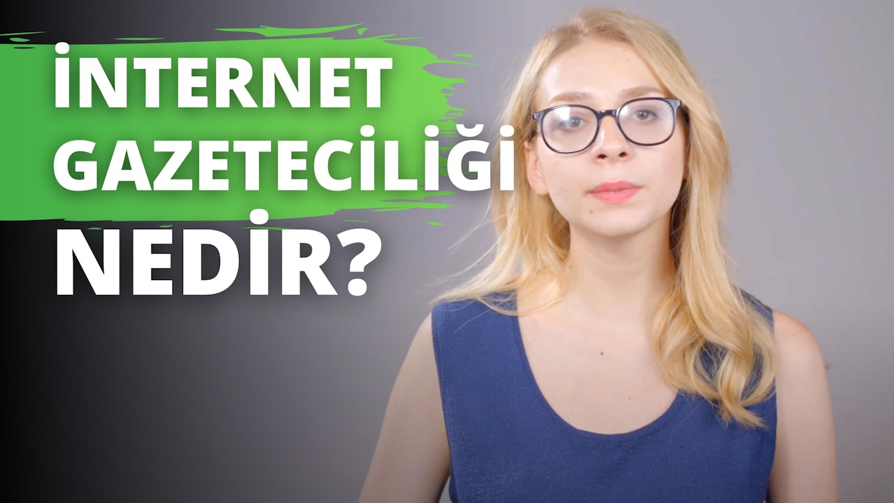 Görüntüde gözlüklü bir kadın görülüyor. Mavi bir atlet giymiş ve doğrudan kameraya bakıyor. Gözlükleri siyah ve ince gümüş çerçeveli. Dudaklarını hafifçe ayırmış, dişlerini ve bir gülümseme ipucunu ortaya çıkarıyor. Gözleri kahverengi ve kaşları bakımlı. Görüntünün sol tarafında, kısmen görülebilen yeşil ve beyaz bir tabela var. Resmin sağ tarafında ise siyah beyaz harflerle yazılmış bir logonun yakın çekimi yer alıyor. Siyah zemin üzerinde beyaz bir harf ve gri zemin üzerinde beyaz bir harf bulunmaktadır. Son olarak, bir kişinin dudaklarının ve gözlerinin yakın çekimi yer alıyor. Tüm bu unsurlar bir araya gelerek gözlüklü bir kadının büyüleyici görüntüsünü oluşturuyor.