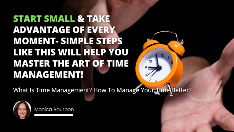 A close-up of a hand holding an orange alarm clock. The clock has a white face with two circular hands and a black rim. The hand is holding the clock in its palm, and the clock is positioned facing the camera. The hand has long, slender fingers and a light tan skin tone. The background is blurry, with a few bright colors visible. The alarm clock is an orange color, and is quite large compared to the hand holding it. It has a few black buttons on its side, indicating that it is an electronic device.