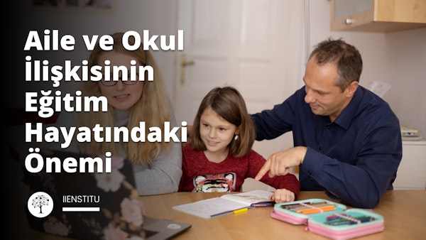 Bir erkek ve bir kız, önlerinde bir dizüstü bilgisayar ile bir masada oturmaktadır. Kız bir kitabı işaret ederken, erkek de kızı işaret ediyor. İkisinin de yüzünde dikkatli ve meraklı ifadeler var. Arka planda bir kalem kutusunun yakın çekimi var. Adam da arka planda hafifçe odak dışında kalan bir beslenme çantasını işaret ediyor. Masanın yan tarafında elinde bir tabletle oturan bir kadın var. Ön planda, siyah zemin üzerinde beyaz bir 'E' harfi var. Son olarak, sağ alt köşede bir halının yakın çekimi var. Sonuç olarak, bu görüntü bir erkek ve bir kızın birlikte çalışma ve keşfetme anını yakalıyor.