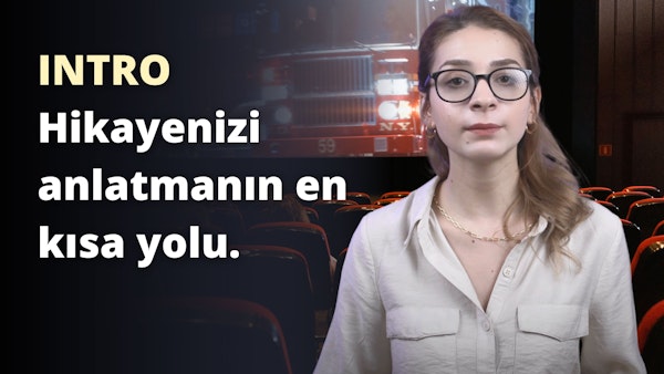 Beyaz gömlekli ve gözlüklü bir kadın kameranın önünde kendinden emin bir şekilde duruyor. Gözlükleri hafifçe renklendirilmiş ve yüzü ışıkla aydınlatılmıştır. Yüzünün yakın çekiminde görülebilen altın zincirli bir kolye takmaktadır. Gözlüklerinin arkasına kısmen gizlenmiş gözlerinde kararlı bir ifade vardır. Beyaz gömleğinin üzerinde beyaz harflerle siyah beyaz bir işaret ve siyah zemin üzerinde beyaz bir numara var. Arka planda beyaz bir nesnenin bulanık görüntüsü ve siyah zemin üzerinde beyaz bir harf var. Tüm bu unsurlar bir araya gelerek stilini güvenle sergileyen bir kadın imajı yaratıyor.
