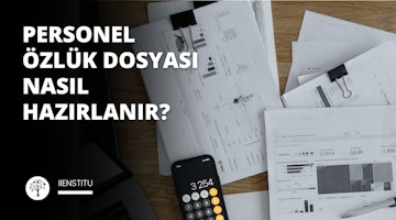 Hesap makinesi ve kağıtların bulunduğu bir masa bu görüntünün odak noktasıdır. Masanın sağında hesap makineli bir cep telefonu, solunda ise noktalı ve çizgili siyah beyaz bir ağaç duruyor. Merkeze yakın bir kağıt yığınının üzerinde bir kalem, kağıtların üzerinde de bir telefon ve hesap makinesi duruyor. Köşede bir dizüstü bilgisayar ekran görüntüsü görülüyor. Sağda, siyah bir arka plan üzerinde beyaz bir harf görülüyor ve görüntünün sağ üst kısmında bir kişinin yüzünün yakın çekimi yer alıyor. Son olarak, sağ altta bir kalemin yakın çekimi yer alıyor. Masa çerçevenin merkezinde yer alıyor ve etrafındaki nesneler görüntüye bağlam sağlıyor.