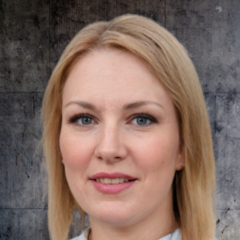 The woman in the picture has long, bright blonde hair that falls to her shoulders. Her face is illuminated by a warm, golden sunshine, and her lips are slightly parted in a gentle smile. She is wearing a white top and jeans, and her hands are resting comfortably in her lap. She has an air of serenity about her, and her gaze is peaceful and content. Her long eyelashes flutter slightly in the wind, and her eyes are a deep and vibrant blue. Her hair is pulled back from her face, and her skin is soft and flawless. She looks happy and relaxed. The perfect setting for a day of peaceful contemplation.