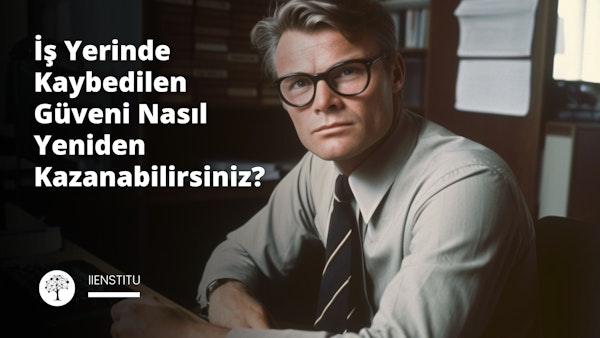Bir adam gözlük takıyor ve kravat takıyor. Göğsünün sol tarafında siyah beyaz bir logo var. Yüzü yakın plandadır ve gözlük takmaktadır. Kravatı ön plandadır ve çoğunlukla odaktadır. Arka planda siyah zemin üzerinde beyaz bir e harfi var. Görüntüde hafif bir bulanıklık var ve arka planda beyaz bir kumaş var. Adam siyah bir takım elbise ve beyaz bir gömlek giyiyor. Saçları düzgünce yana taranmış. Gözleri ileriye bakıyor ve yüzünde ciddi bir ifade var. Modern ve profesyonel bir ortamda durmaktadır.