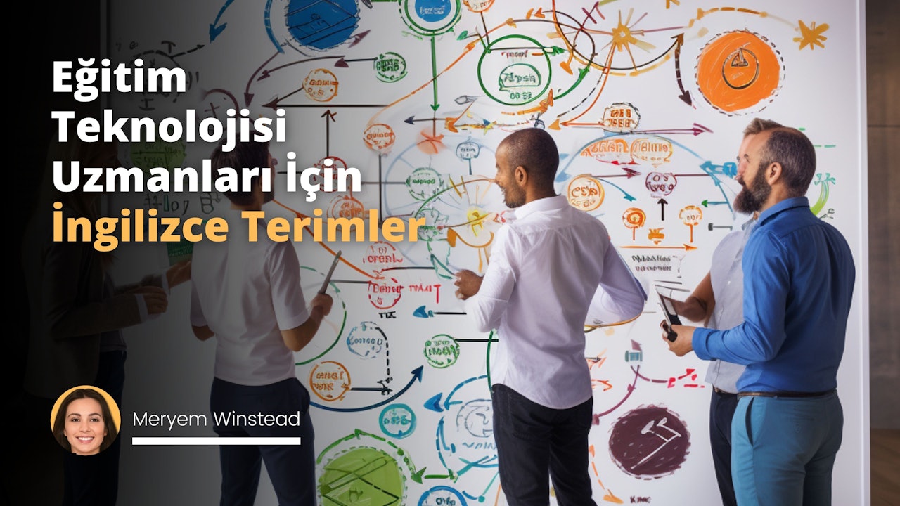 Resim, bir grup eğitim teknolojisi uzmanının büyük bir beyaz tahta önünde durduğunu göstermektedir. Uzmanlar, önceden belirlenmiş terimler ve açıklamaları, tahtada renkli keçeli kalemler ile yazılı halde organize şekilde yuvarlak bir şema oluşturuyorlar. Merkezde 'Eğitim Teknolojisi' yazılı büyük bir daire var ve bu daireden çıkan oklarla çevredeki daha küçük dairelere bağlanıyor. Her küçük dairede, başlıca İngilizce eğitim teknolojisi terimlerinin yanı sıra çeşitli yöntemler, uygulamalar ve araçların adı bulunuyor. Uzmanların bazıları aktif olarak tahtaya yazarken, bazıları da oturmuş ve tartışıyor. Odanın geri kalan kısmında, kitap rafları ve teknolojik ekipmanlar görülebiliyor. Son olarak, tahtanın üzerinde 'Eğitim Teknolojisi Temel Terimler ve Anlamları' başlığı yazılı.