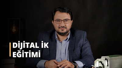 Lacivert takım elbise giyen orta yaşlı bir adam beyaz bir arka planın önünde duruyor. Sakallı ve kalın çerçeveli bir gözlük takıyor. Başı hafifçe eğiktir ve bakışları yukarı doğru yönelmiştir. Kendinden emin bir ifadesi var ve ellerini iki yanında tutuyor. Lacivert takım elbisesinin tek düğmeli, iki düğmeli ve sivri yakalı bir ceketi vardır. Beyaz gömleği ceketin altından görünmektedir ve şal desenli bir kravatla süslenmiştir. Adamın kol saati ve altın bir yüzüğü var. Sonuç olarak, dünyaya meydan okumaya hazır görünüyor.