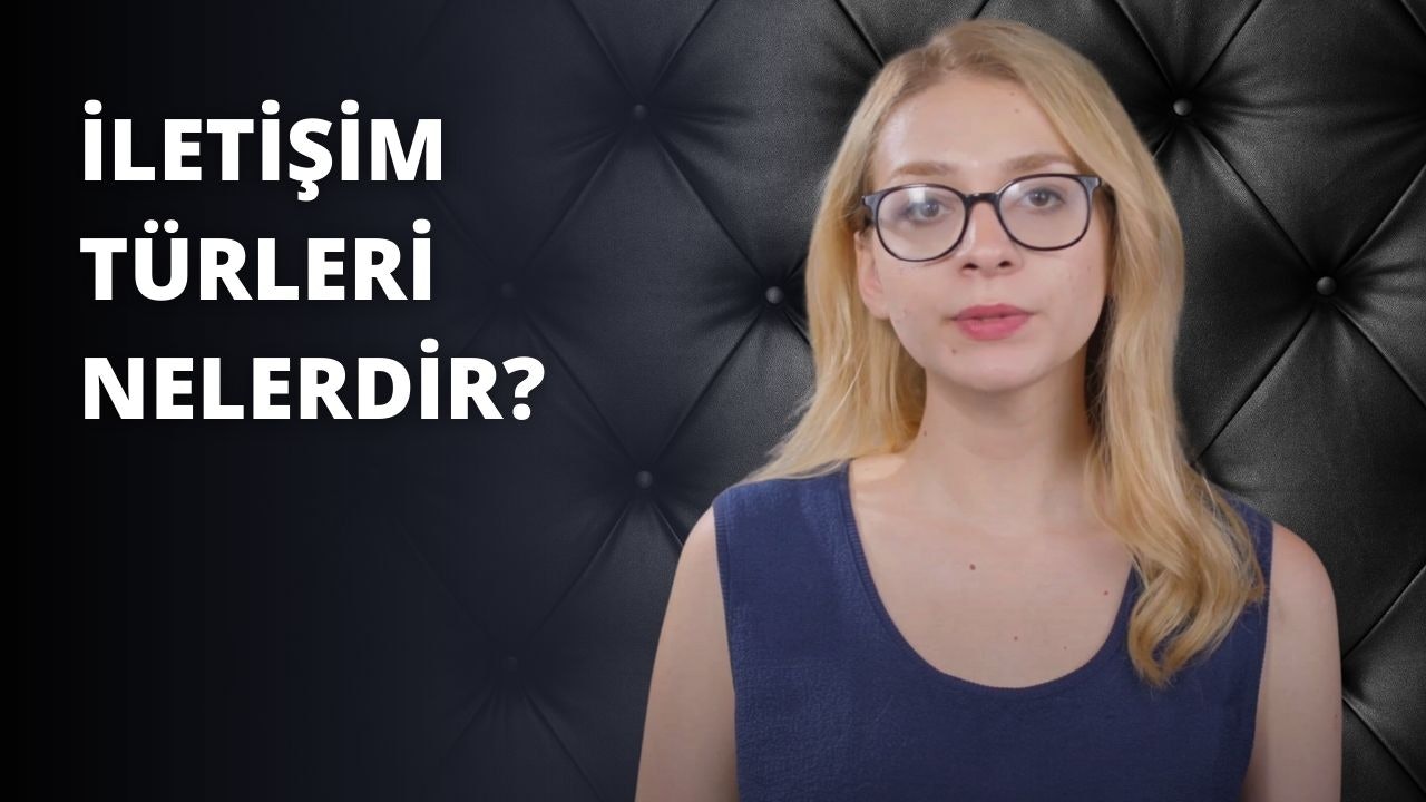 Mavi gömlekli, gözlüklü bir kadın beyaz bir fonun önünde duruyor. Bakışları odaklanmış ve saçları arkaya toplanmış bir şekilde dümdüz karşıya bakıyor. Gözlüklerinin çerçeveleri nettir ve gömleğinin mavisi ten rengiyle tezat oluşturmaktadır. Kollarını iki yana açmış ve ellerini birbirine kenetlemiş. Yüz ifadesi sakin ve gözleri doğrudan bir bakışa kilitlenmiş. Küçük, narin bir burnu ve dolgun yanakları vardır. Ağzı hafifçe açık ve dudakları nötr bir ifadeye sahip. Güçlü bir çene hattına sahiptir ve çenesi hafifçe yukarı doğru eğiktir. Boynu incedir ve köprücük kemikleri görülebilir.