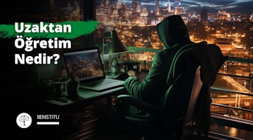 Bir kişi dizüstü bilgisayarın önündeki sandalyede oturmuş, elleriyle klavyede hızlıca bir şeyler yazmaktadır. Dizüstü bilgisayar ekranı aydınlatılmış ve parlak, renkli bir görüntü sergiliyor. Sandalyenin üzerine serilmiş yeşil ve siyah bir battaniye ortama rahatlık katıyor. Kişinin ayakları bir su kütlesine bakan bir çıkıntının üzerinde durmakta ve görüntüye gece vakti bir şehir silüetinin fonunu vermektedir. Kişinin klavyedeki ellerinin yakın çekimi ve bilgisayar ekranının yakın çekimi görüntüye ayrıntı katıyor. Kişi, dizüstü bilgisayarda yazarak elindeki işe yoğun bir şekilde konsantre olmuş gibi görünüyor.