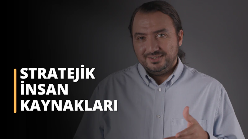 Fotoğrafta, koyu renkli bir arka plana karşı açık renkli bir gömlek giyen bir erkek akademisyen bulunuyor. Kişi kameraya doğru bakıyor ve eliyle hafif bir hareket yapıyor gibi görünüyor. Bu bir eğitim sahnesinden alınmış. Ayrıca fotoğrafta "STRATEJİK İNSAN KAYNAKLARI" yazısı yer alıyor. Bu stratejik insan kaynakları yönetimi eğitimi kapak görselidir.