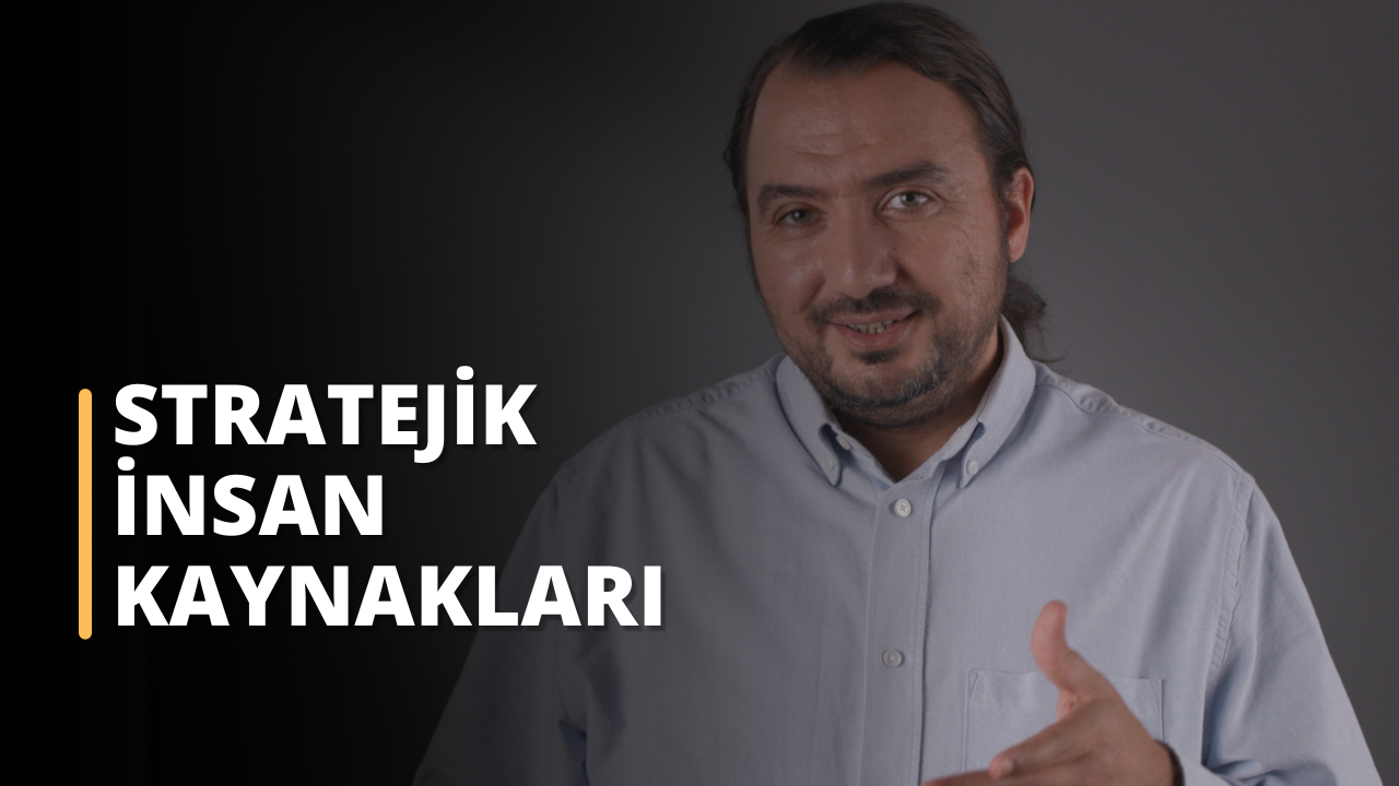 Fotoğrafta, koyu renkli bir arka plana karşı açık renkli bir gömlek giyen bir erkek akademisyen bulunuyor. Kişi kameraya doğru bakıyor ve eliyle hafif bir hareket yapıyor gibi görünüyor. Bu bir eğitim sahnesinden alınmış. Ayrıca fotoğrafta "STRATEJİK İNSAN KAYNAKLARI" yazısı yer alıyor. Bu stratejik insan kaynakları yönetimi eğitimi kapak görselidir.