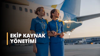 Bu görsel bir Ekip Kaynak Yönetimi Eğitimi kursunu tasvir etmektedir. Görselde havalimanında çalışan iki kişi yer almaktadır, bu havacılıkta ekip kaynak yönetimini ve etkili iletişim ve işbirliğinde beden dilinin önemi gösterilmektedir. Bu eğitim sayesinde katılımcılar, ekip kaynaklarını verimli bir şekilde yönetmek ve istenen sonuçları elde etmek için gerekli bilgi ve becerileri kazanacaklardır. Görevleri etkin bir şekilde devretmeyi, ekip faaliyetlerini koordine etmeyi ve ekip üyeleriyle güçlü ilişkiler kurmayı öğreneceklerdir. Ayrıca, başarılı ekip kaynakları yönetiminde iletişimin, problem çözmenin ve karar vermenin önemine dair bir anlayış geliştireceklerdir.