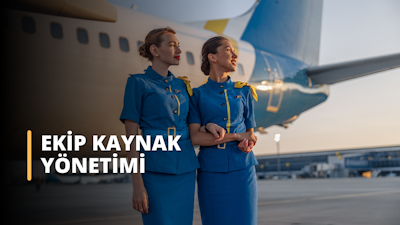 Bu görsel bir Ekip Kaynak Yönetimi Eğitimi kursunu tasvir etmektedir. Görselde havalimanında çalışan iki kişi yer almaktadır, bu havacılıkta ekip kaynak yönetimini ve etkili iletişim ve işbirliğinde beden dilinin önemi gösterilmektedir. Bu eğitim sayesinde katılımcılar, ekip kaynaklarını verimli bir şekilde yönetmek ve istenen sonuçları elde etmek için gerekli bilgi ve becerileri kazanacaklardır. Görevleri etkin bir şekilde devretmeyi, ekip faaliyetlerini koordine etmeyi ve ekip üyeleriyle güçlü ilişkiler kurmayı öğreneceklerdir. Ayrıca, başarılı ekip kaynakları yönetiminde iletişimin, problem çözmenin ve karar vermenin önemine dair bir anlayış geliştireceklerdir.