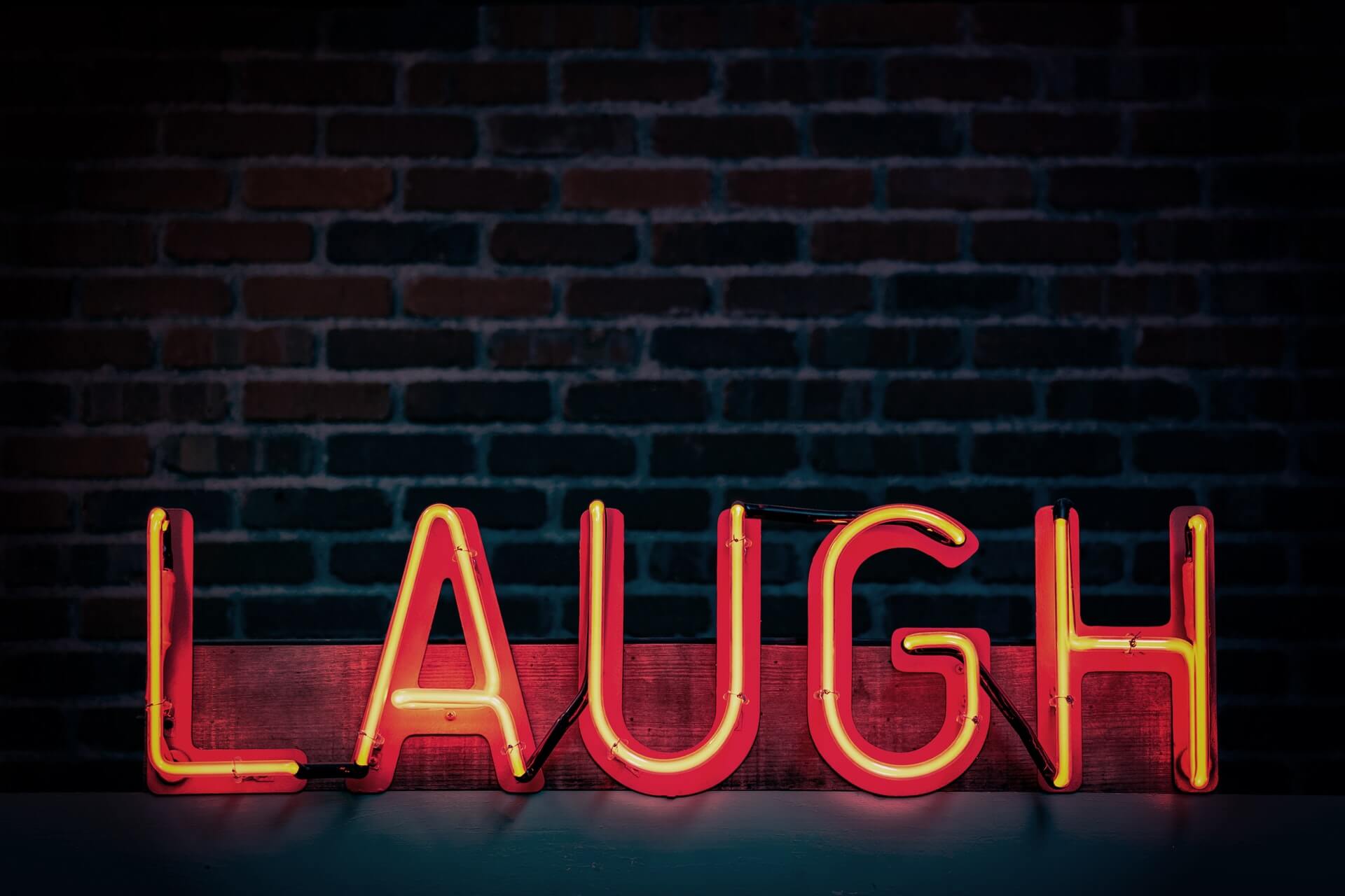Escrita "laugh" em letra neon (risada em inglês)
