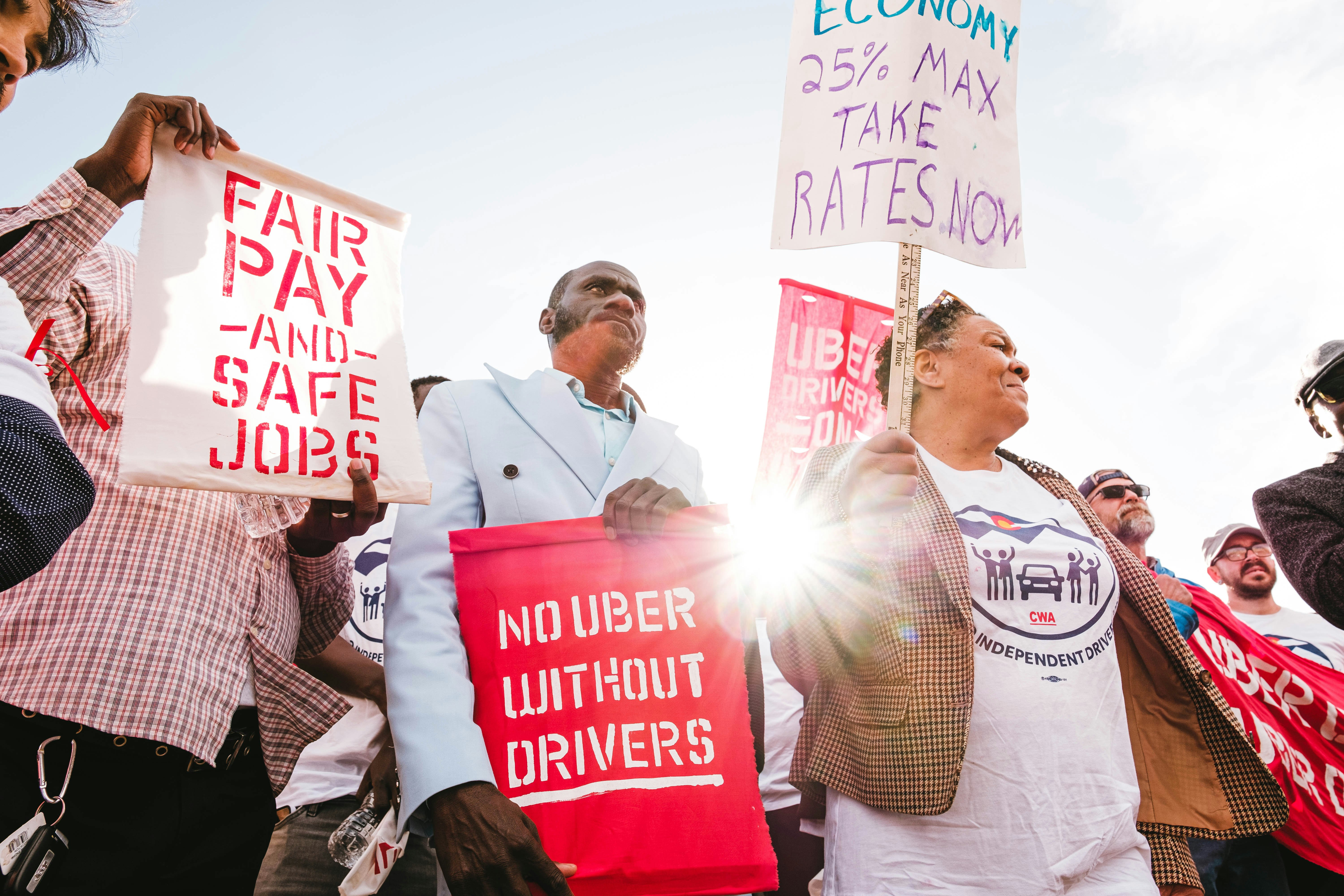 Uber drivers and allies rallying with Colorado Independent Drivers United and PowerSwitch Action at Denver Intl Airport on 5/4/23. People holding signs that say "No Uber Without Drivers" and "Fair Pay and Safe Jobs"