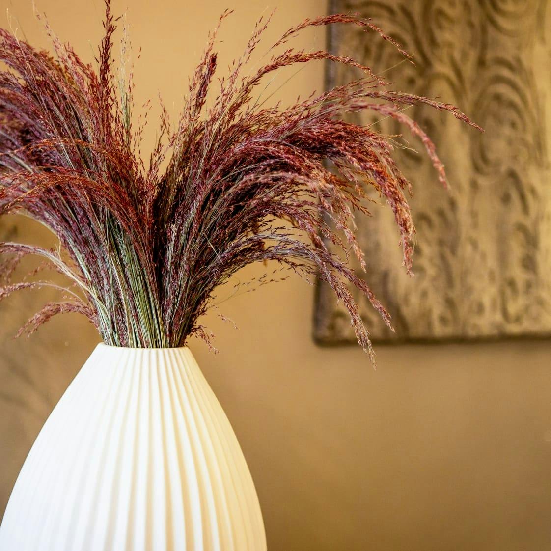 a white vase holding a plant