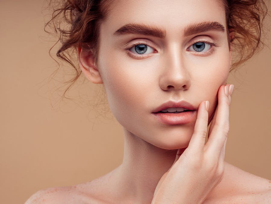 red haired woman touching face