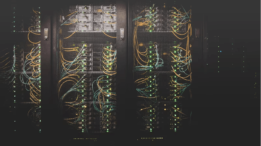 Server closet with green lights and lots of wires