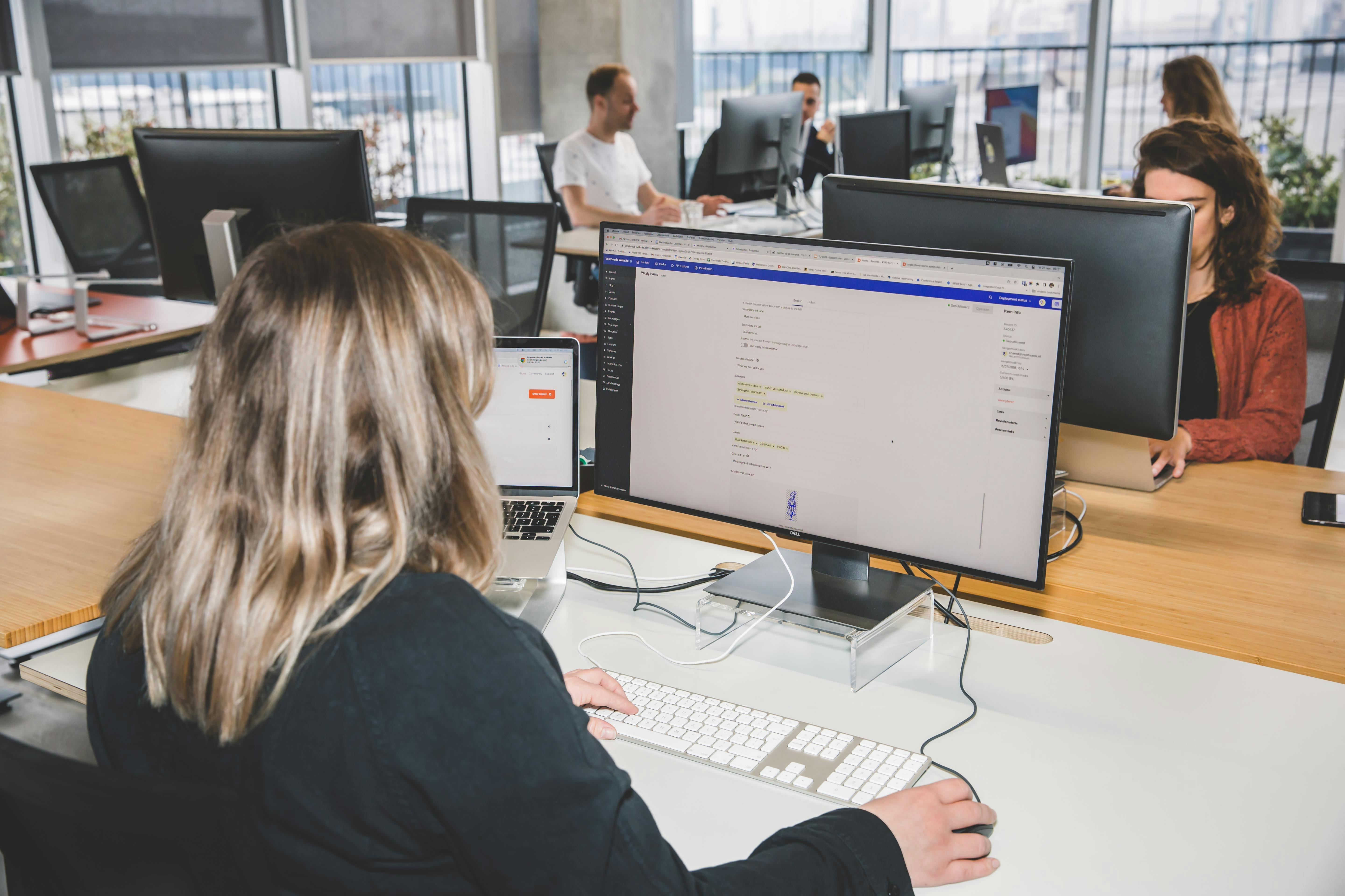 A woman working in a headless cms editor at a desktop computer