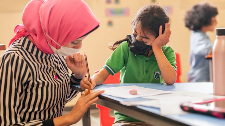 A pupil is helped with their work at The WellSpring School, RAK