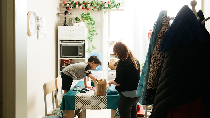 A mum and son undertake a craft activity together at the kitchen table