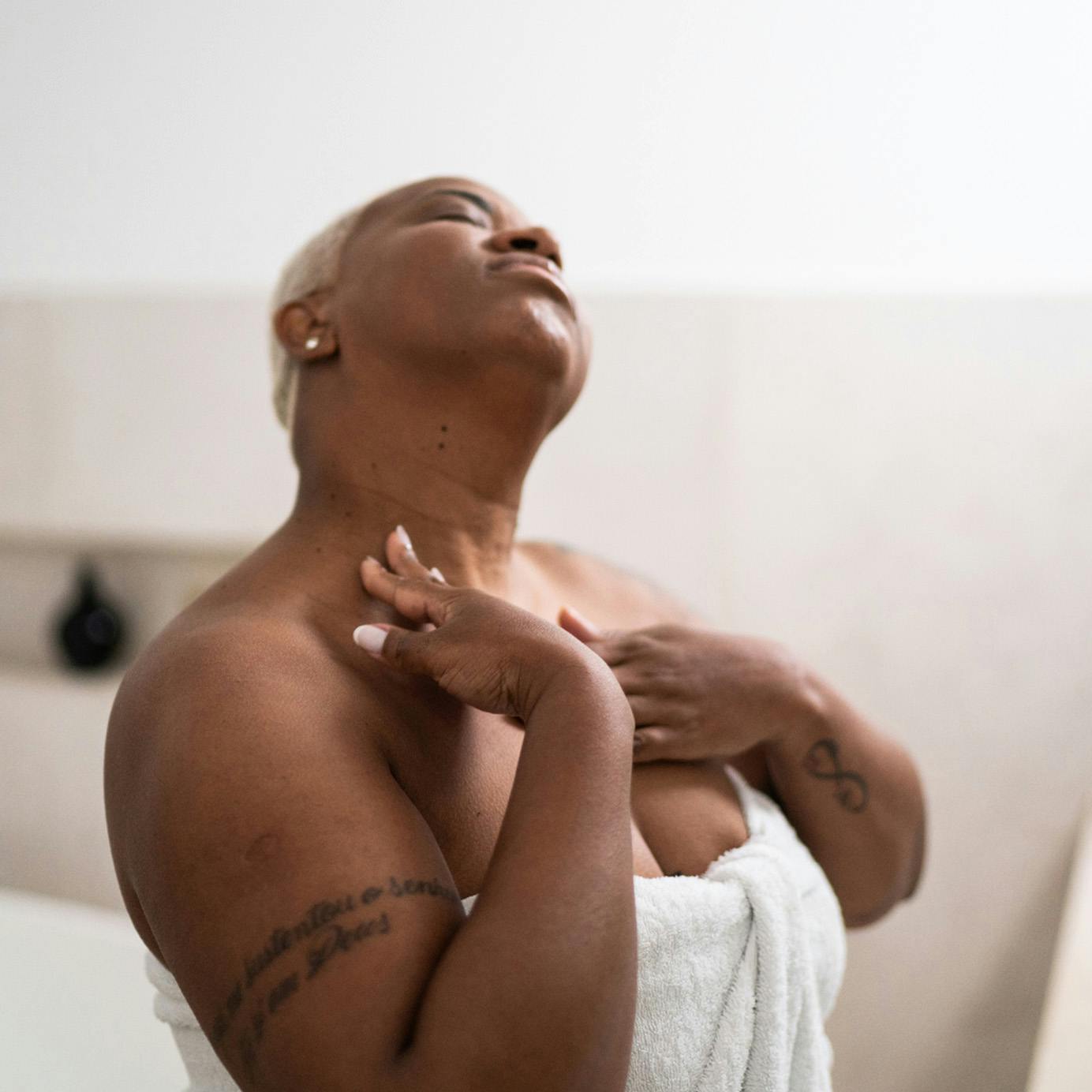 Woman in a towel touching her neck