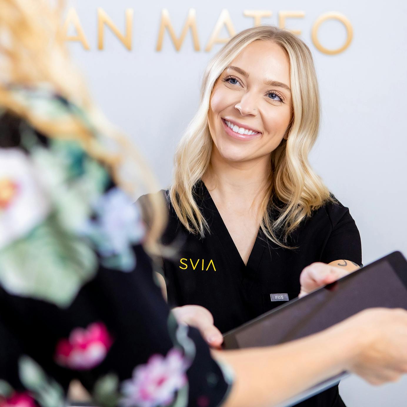 Staff at SVIA handing woman tablet