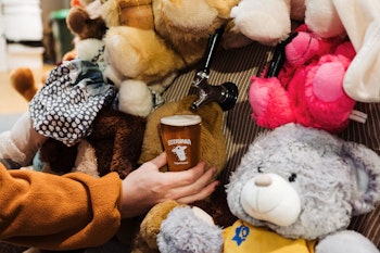 Pouring a beer from Abandoned' teddy bear stand