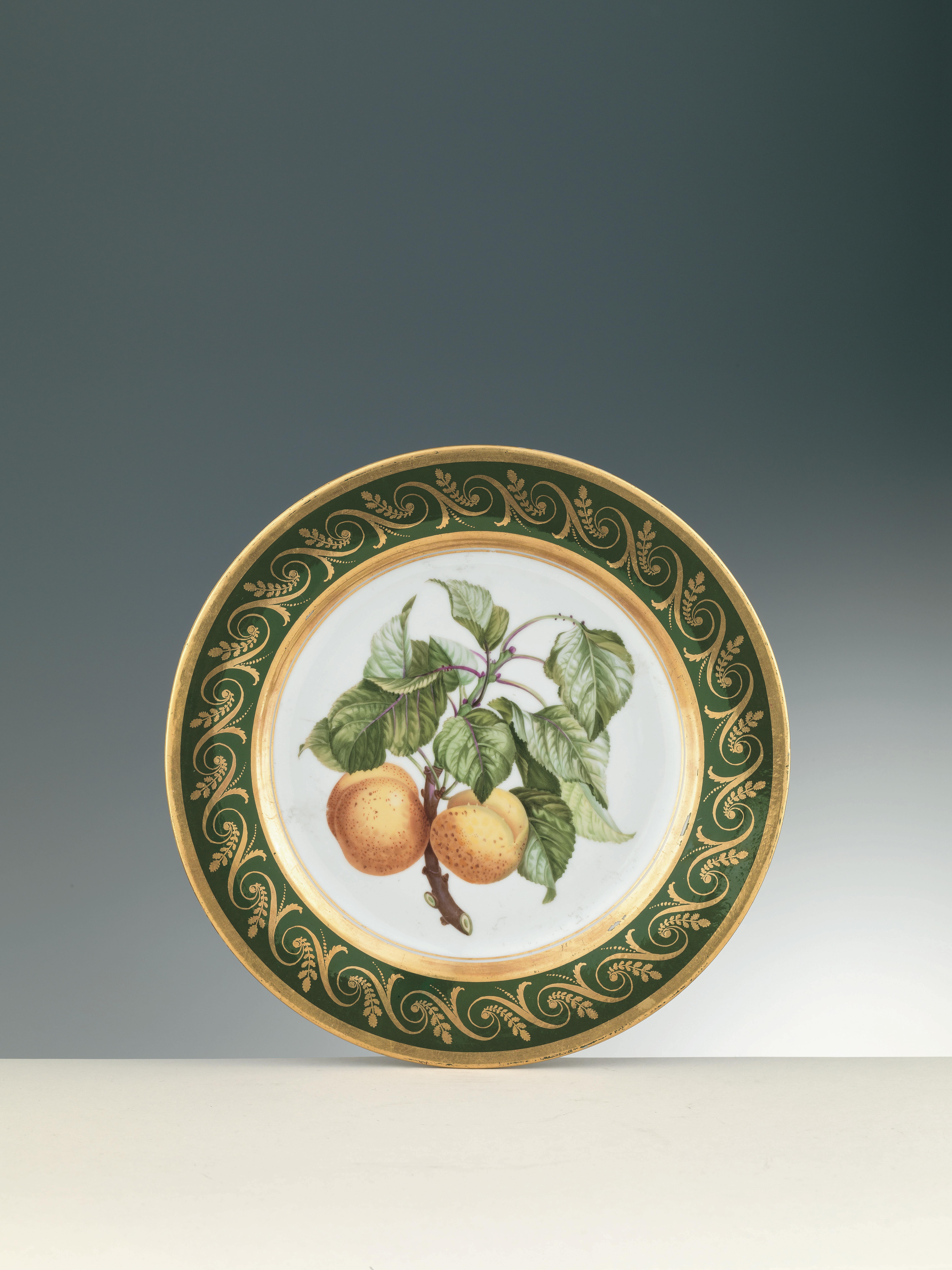 White plate with green leaves and two orange fruits