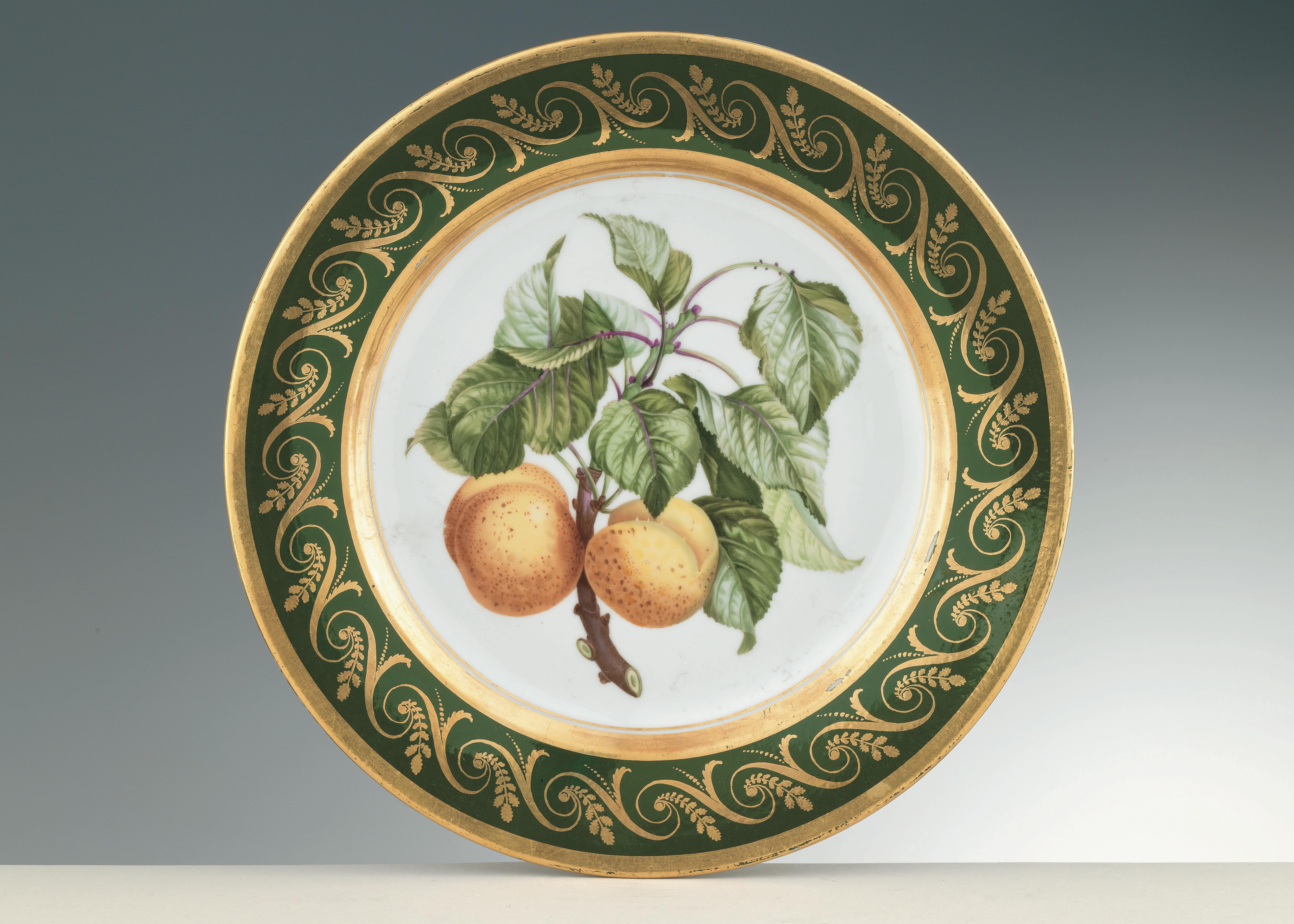 piatto bianco con foglie verdi e due frutti arancioni