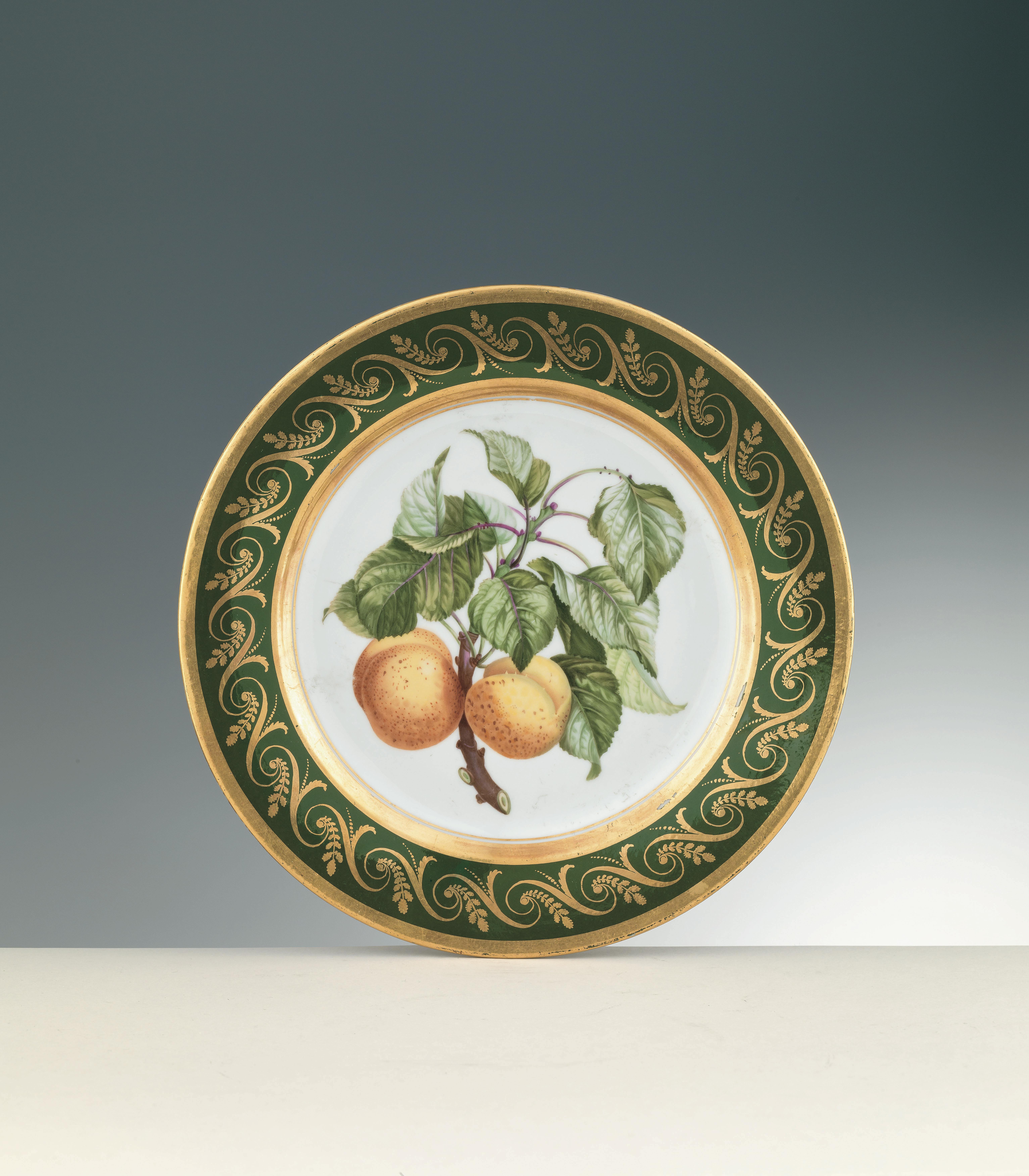 piatto bianco con foglie verdi e due frutti arancioni
