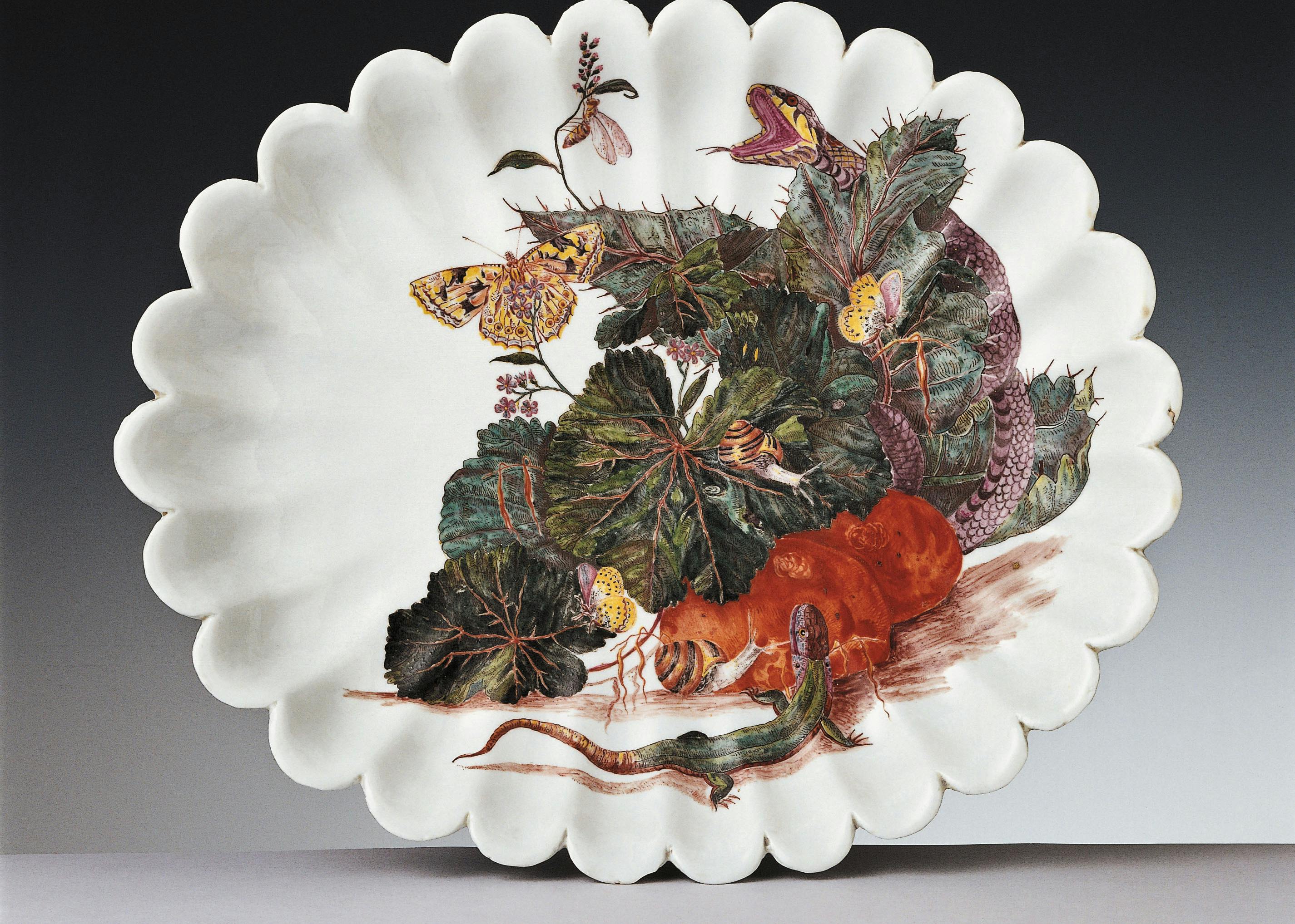 Piatto in porcellana bianca con un decoro colorato raffigurante un sottobosco popolato da una lucertola, due lumache, alcune farfalle, una vespa e un serpente