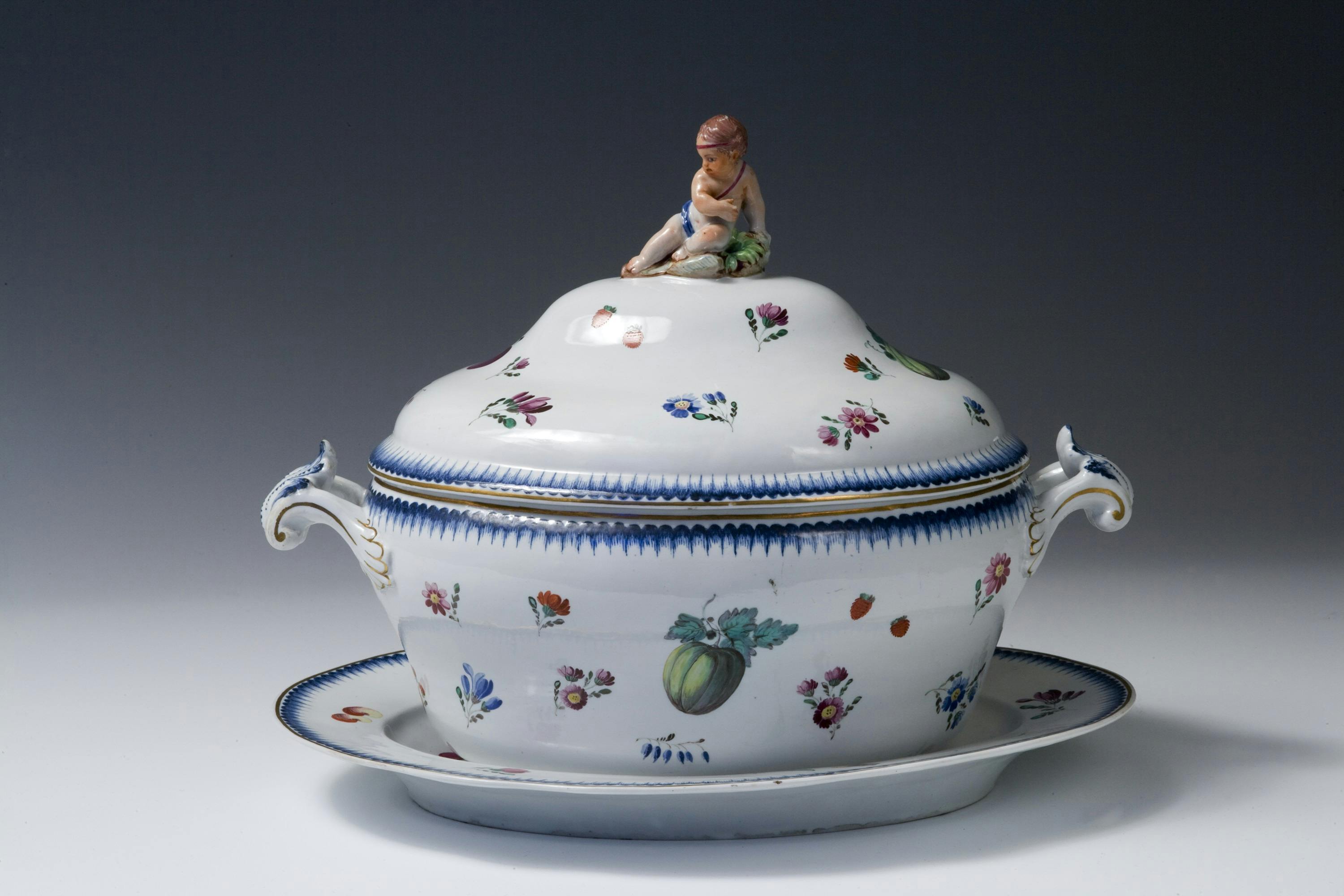 Zuppiera bianca decorata con frutti colorati e foglie verdi con bordi color oro e blu