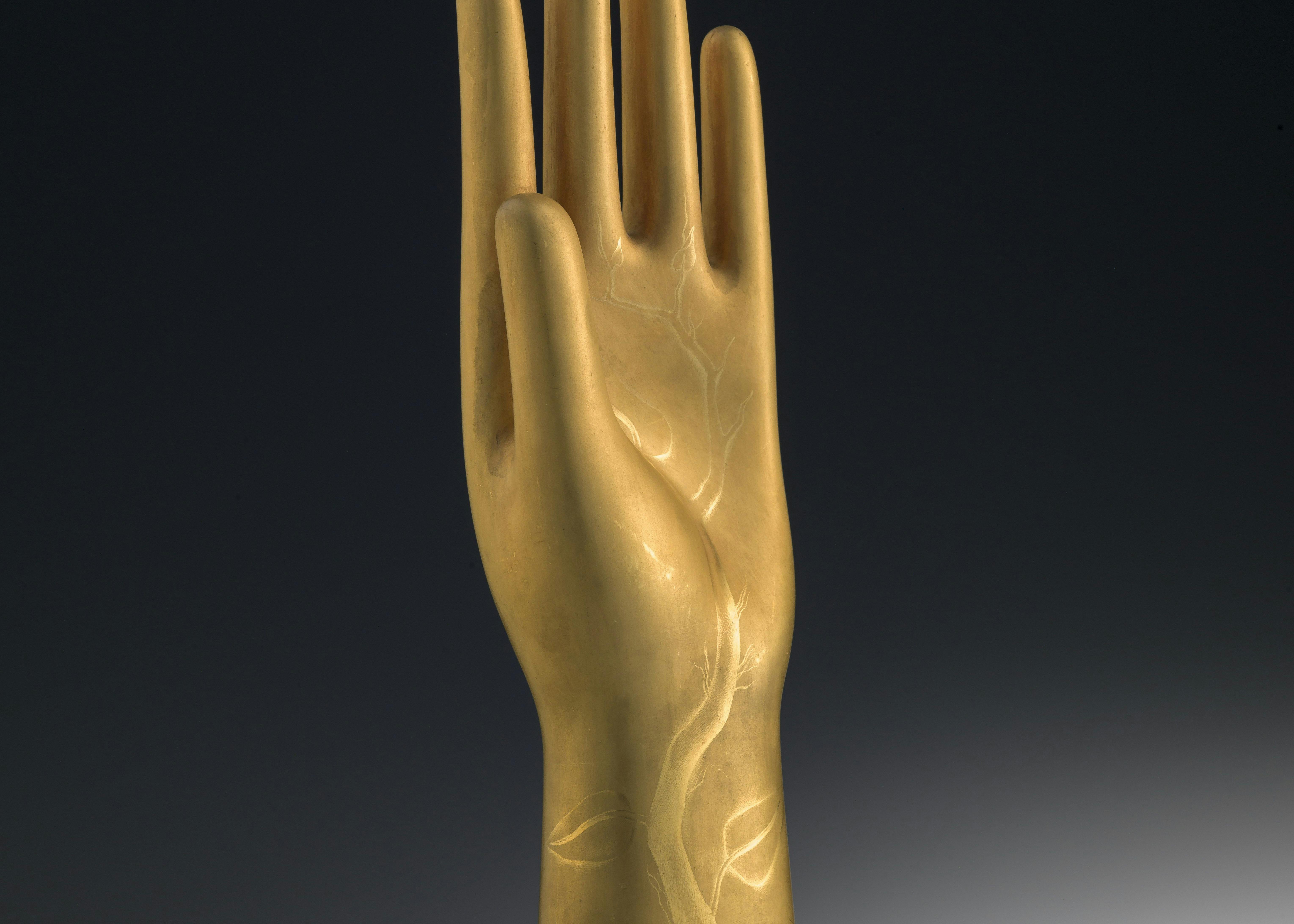 Scultura dorata a forma di mano