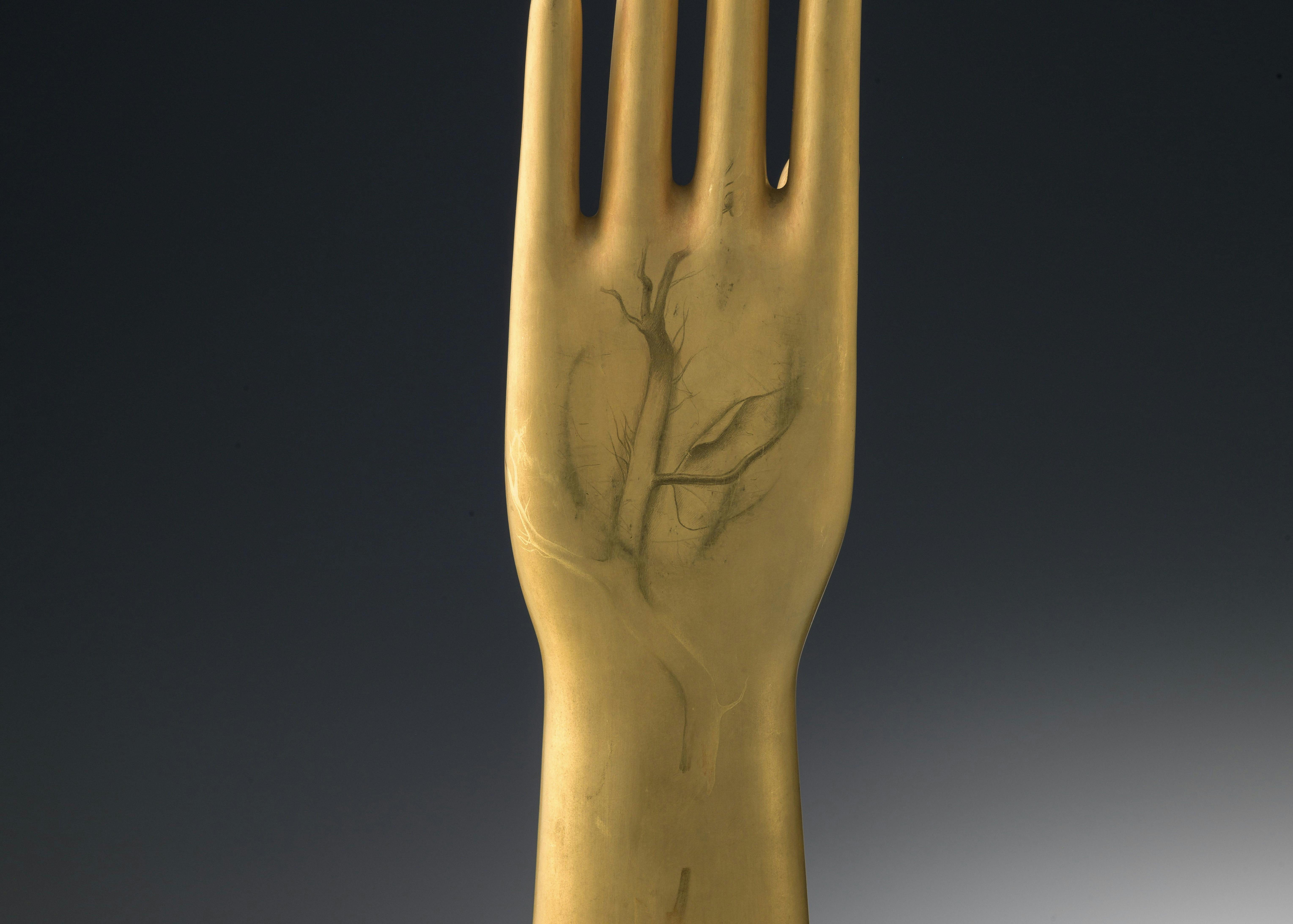 Scultura a forma di mano decorata in oro